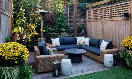 Patio.,Garden.,Urban,,Neutral,,Outdoor,Living,Space.,Exterior,Photo.,Outdoor Patio. Garden. Urban, neutral, outdoor living space. Exterior photo. Outdoor living room with couch, comfy cushions, throw pillows, love seat, chairs and coffee table. Backyard with greenery, plants.